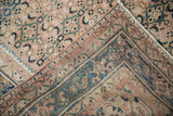 Distressed vintage Hamadan rug corner with blush, navy, teal patterns, even wear, and machine-bound edge.