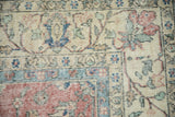 Detail of vintage Sparta carpet showing distressed pile, cochineal red, blue floral palmettes and vinery.