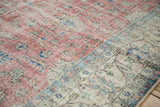 Textured vintage Sparta carpet showing foundation with faded red, ivory, and blue floral patterns.