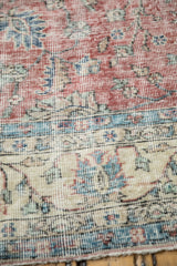 Distressed Turkish Sparta carpet, showing faded red, ivory border, and visible foundation.