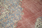 Distressed dusty burgundy field next to faded sky blue and ivory curvilinear pattern on vintage Sparta rug.