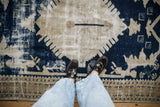Distressed vintage Oushak rug texture with worn cobalt blue and beige geometric motifs.