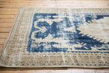 Distressed Turkish Oushak rug pile revealing worn cobalt blue patterns and exposed foundation.