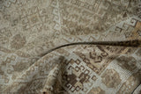 Textured pile of a distressed Kurd rug, showcasing softened geometric motifs in earth tones.