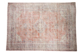 Vintage distressed Sparta carpet with a diamond medallion over a floral field in faded terracotta and soft blue.