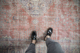 A personal, top-down view of a distressed Sparta carpet's worn texture in terracotta and blue.