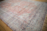 Angled view of the weeping willow border in faded royal blue and terracotta on a vintage Sparta carpet.