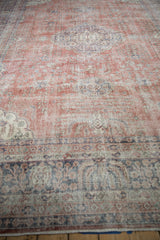 Low angle view of a distressed Sparta carpet highlighting the time-softened texture of its terracotta and blue design.