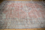 Distressed terracotta and faded blue hues across the length of a vintage hand-knotted Sparta carpet.