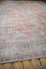 The worn texture and low pile of a distressed Sparta carpet with faded terracotta and muted blue details.