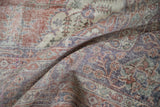 Worn texture and knot heads on a distressed Sparta carpet in terracotta, violet, and ivory.