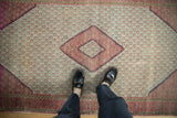 Repeating magenta boteh motifs and zig-zag border details of a hand knotted Hamadan rug.