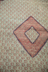 Repeating raspberry red blossoms and navy diamond detail on a vintage Hamadan rug.