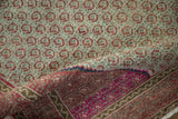 Curled vintage Hamadan rug, revealing repeating red boteh motifs on light pile and fuchsia, blue reverse.