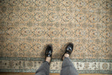 Distressed texture and low pile of a vintage Turkish Sparta rug with a roundel vine pattern in sand and pale blue.