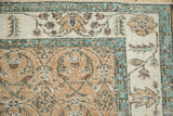 Detail of the even wear and abrashed floral border on a distressed Sparta rug runner.