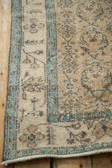 Texture of a distressed Sparta rug showing even wear to the knot heads and a pale blue floral border.