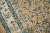Even wear showing knot heads and foundation through the sand and pale blue pile.