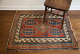 Worn edge and intricate geometric borders on the tribal rug's corner.