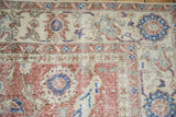 Distressed vintage Turkish Sparta carpet showcasing dusty brick red and cobalt blue roundel floral patterns.