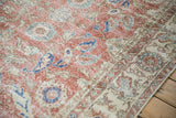 Distressed vintage Turkish Sparta carpet showing faded brick red field, blue floral patterns, worn pile.