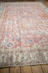 Distressed Turkish Sparta carpet, showing worn dusty brick red, blue, and beige floral motifs.