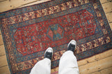 Vintage Malayer rug showing the blue center medallion on a red Herati-filled field.