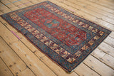 Vintage fine Malayer rug viewed from an angle, highlighting its red Herati field and blue medallion.
