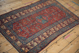 Angled view of a fine vintage Malayer rug showcasing its traditional red and blue Herati pattern.