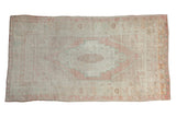 Vintage distressed Oushak rug with a central stepped medallion in soft blush, ivory, and pale ocean green.