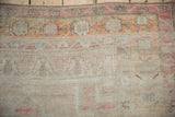 Close-up of the prayer niche end on a distressed Oushak rug in dusty blush and orange.