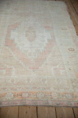 Low angle perspective on a vintage Oushak rug, showing the texture of its abrashed, low pile.