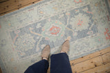 Distressed Turkish Oushak rug with softened pile, pale blue, green palmette motifs.