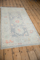 Distressed Oushak rug detail featuring softened pile, powder blue field, and terra cotta palmettes.