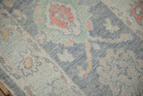 Distressed Oushak rug pile texture with oxidized silver, pale blue, and terra cotta hues.