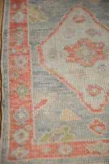 Corner detail of a Turkish Oushak rug showing the grapefruit-hued floral border and hand-knotted pile.
