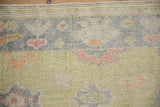 Hand-knotted Oushak rug's textural pile, featuring nuanced palmettes in soft tropical hues.