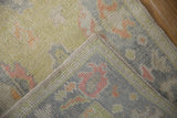 Distressed Oushak rug showing soft textural pile and intact side cording.