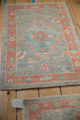 Original side cord selvage and hand knotted pile on the distressed Oushak rug mat.