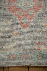 Hand-knotted distressed Oushak rug pile showcasing softened oxidized silver and ruby red.
