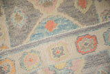 Detail of the Oushak rug's side cord selvage, dividing the silver wool pile and ivory border.
