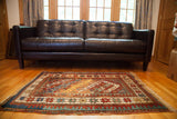Vibrant geometric design and varied star motifs on a colorful antique Kazak rug.