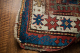 Vibrant blue geometric border, red star motifs, and fringe detail on an antique Kazak rug.