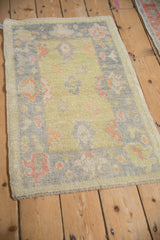 Distressed Oushak rug corner with lime green and oxidized silver tropical palmettes.
