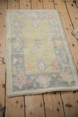Distressed Oushak rug showcasing soft lime, tangerine, and blush tropical palmettes.