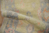 Plush wool pile of the distressed Oushak rug, showing nuanced palmettes in tropical hues.