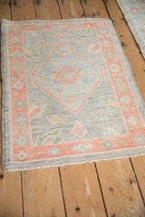 The soft, even wool pile of a distressed Oushak rug mat, shown from a high-angle perspective.