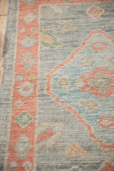 Soft, even pile of a distressed Oushak rug's salmon border and silver-blue ground.