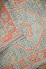 Close-up of the textured wool pile and intact side cord selvage of a Turkish Oushak rug mat.
