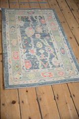 Distressed Oushak runner corner with softened pile, detailed floral palmettes, and intact selvage.